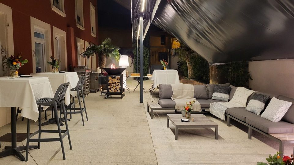 La terrasse un soir de réception : mange-debout, brasero et salon